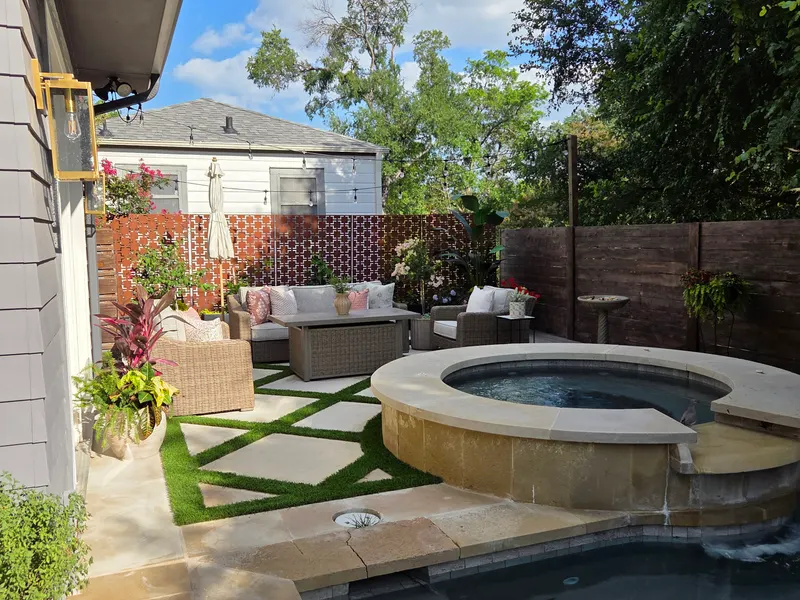 Backyard patio with a spa and turf pavers