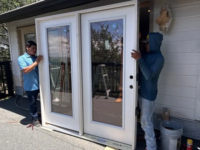 Two workers installing French doors